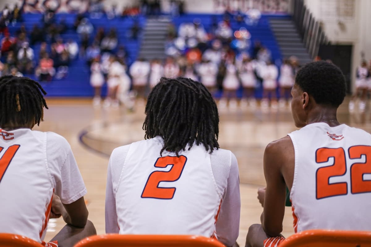 Three teammates watching from the bench